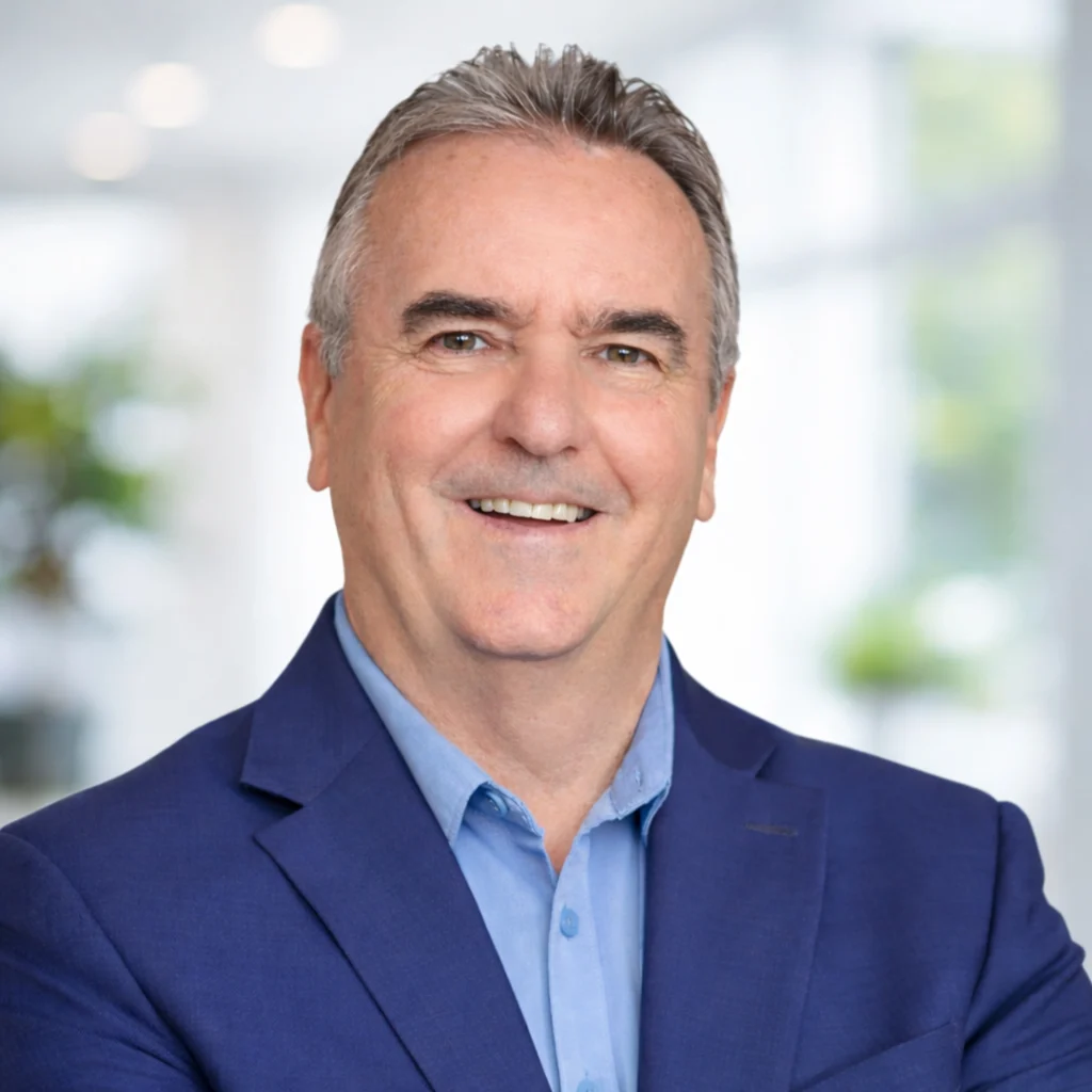 Professional headshot of Daniel J. Levy, Founder and President of BlueCycle Technologies, smiling in a navy blazer against a soft, light-filled background.
