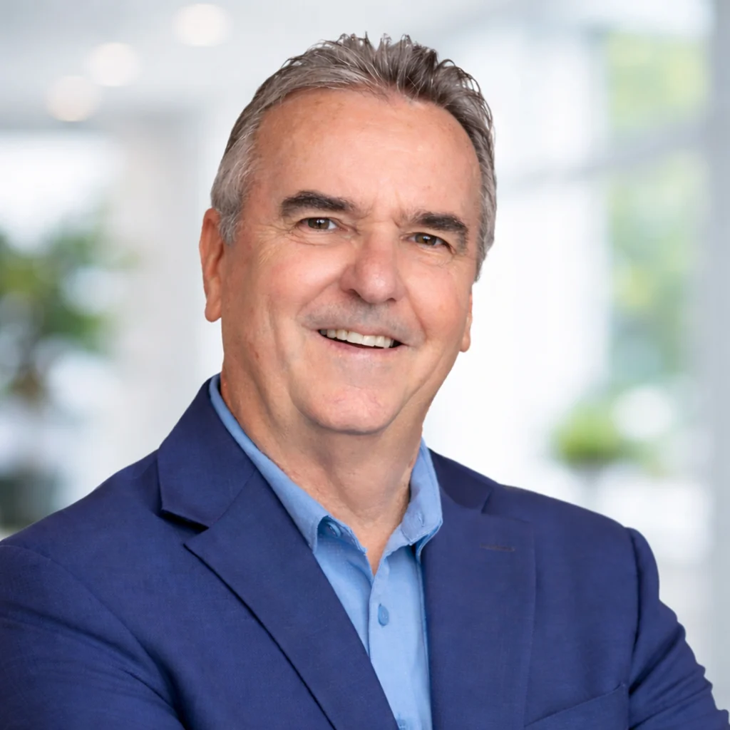 Professional headshot of Daniel J. Levy, Founder and President of BlueCycle Technologies, smiling in a navy blazer against a soft, light-filled background.